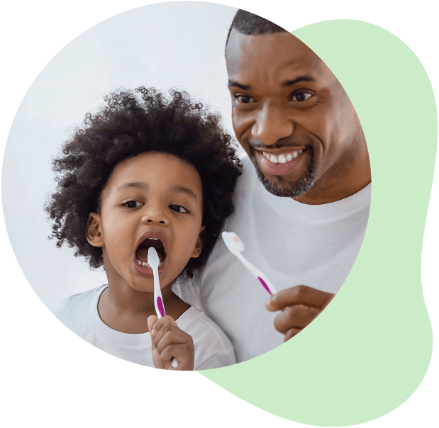 Father and child brushing their teeth together in the morning